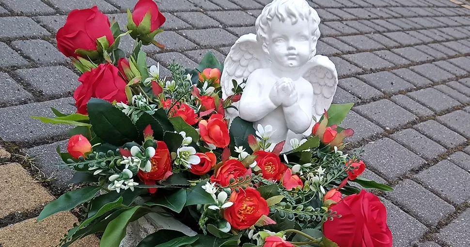 czerwone kwiaty i posąg aniołka